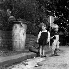 Kinder vor Aschentonne